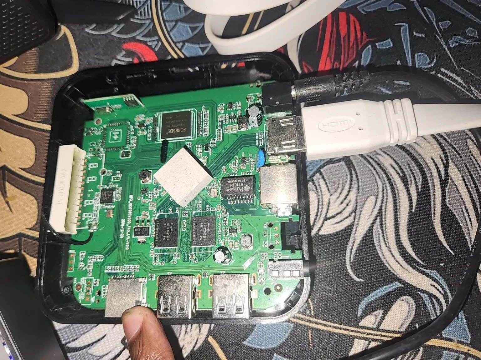 TV Box aberta mostrando placa eletrônica verde e conexões
