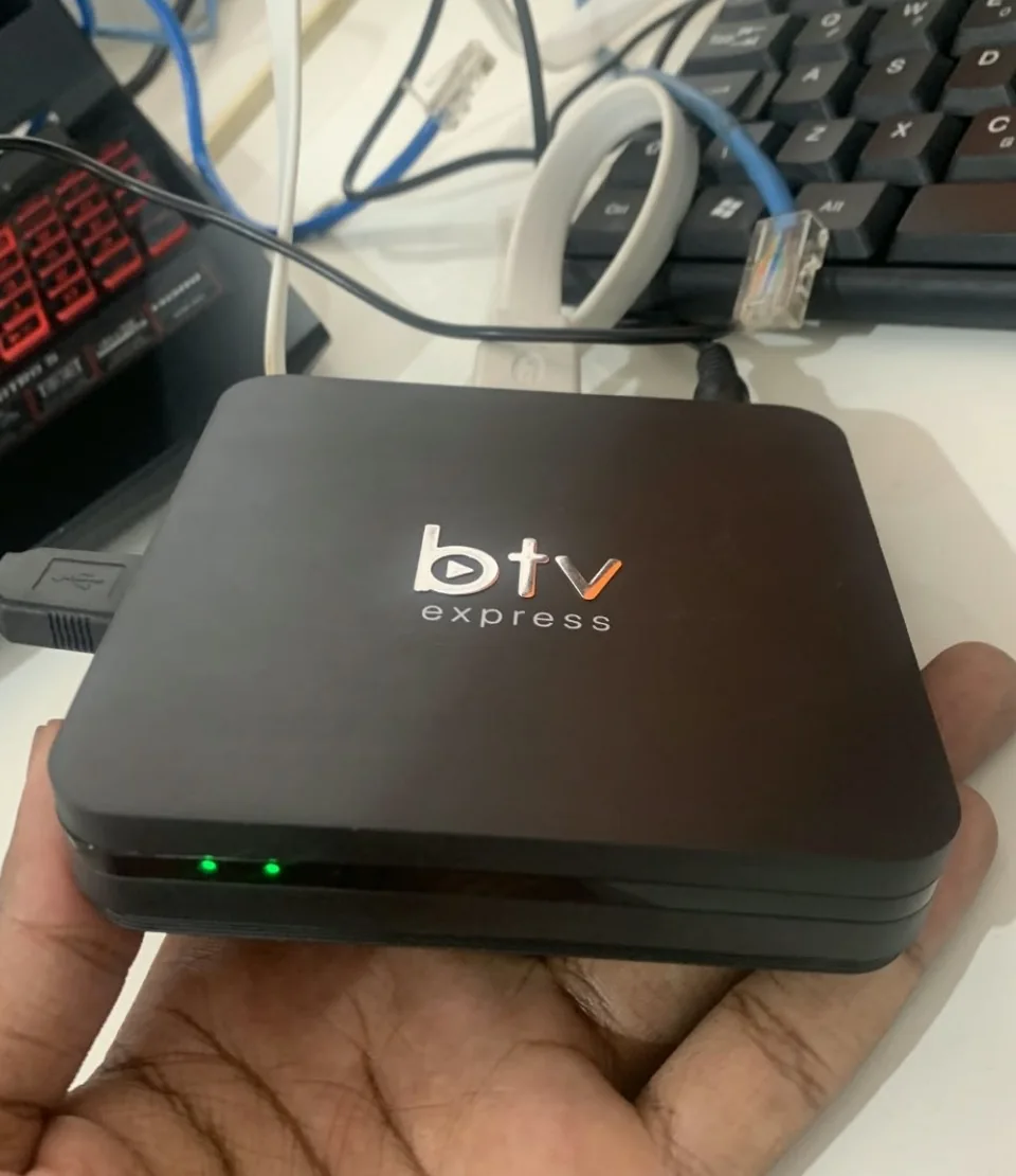 Dispositivo TV Box preto em teste numa bancada de trabalho